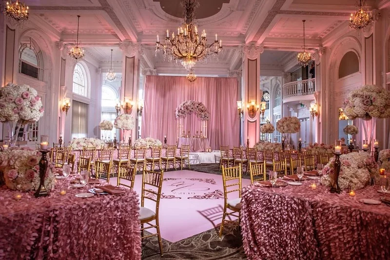 exquisite-sounds-event-lighting A pink and gold wedding reception set up in a ballroom.